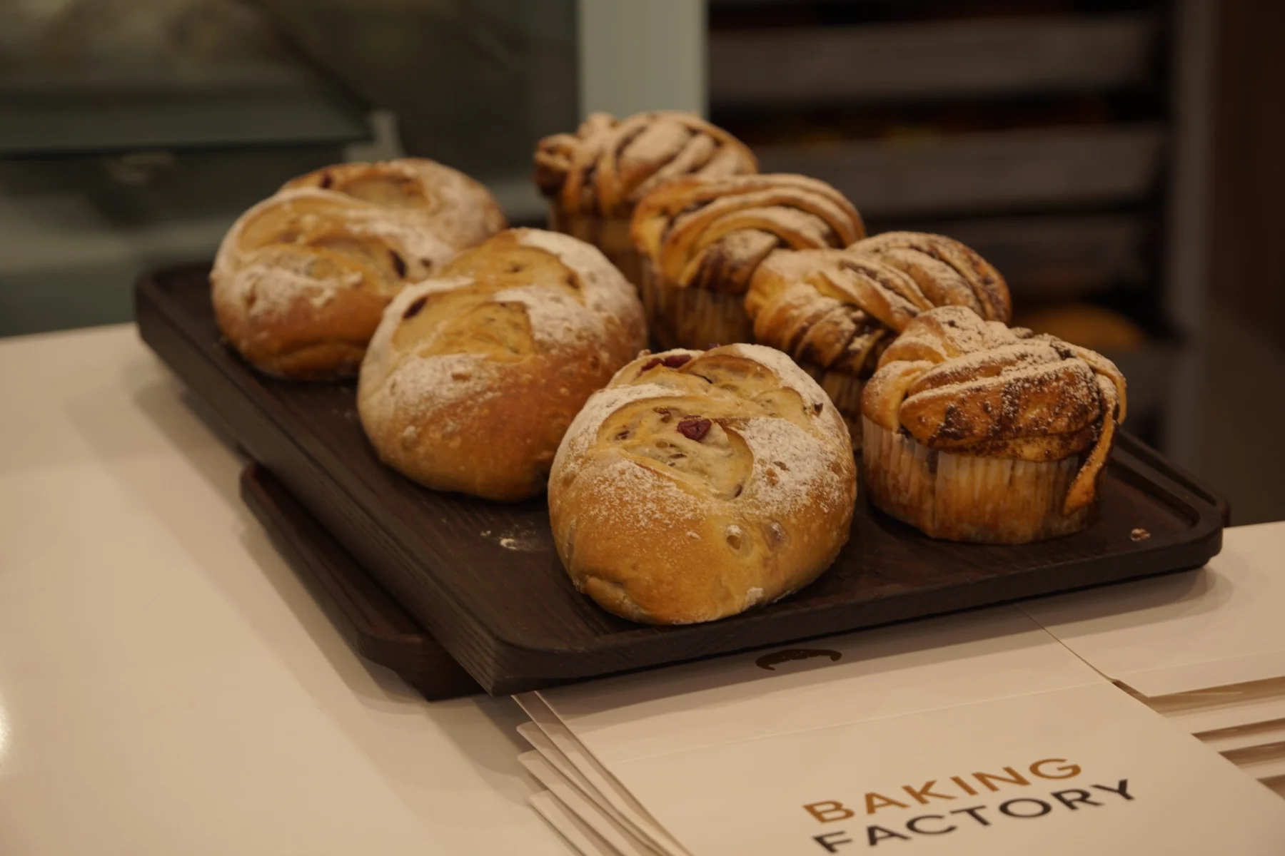 An assortment of flour-dusted loaves and swirled breads on a tray