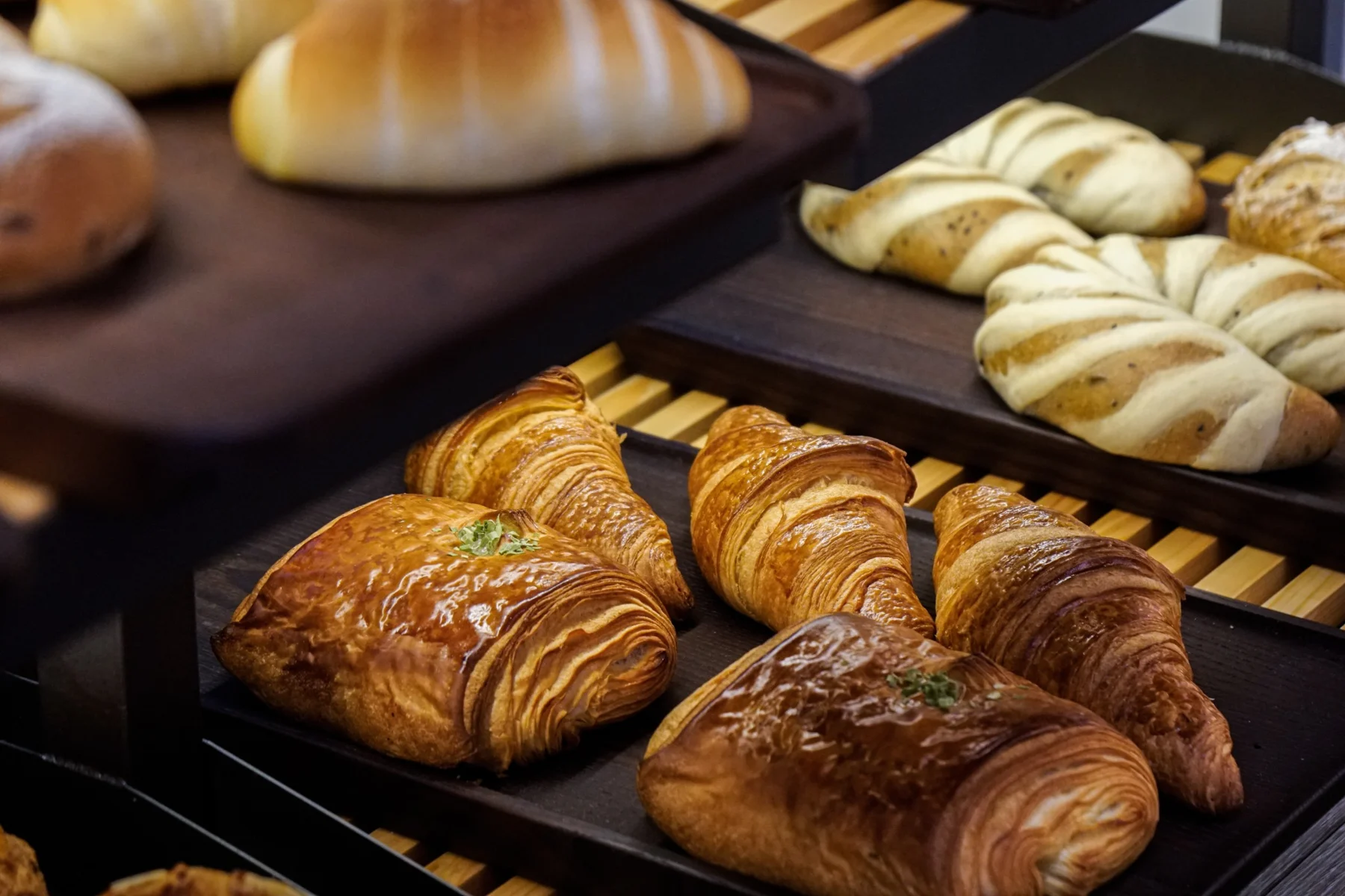 Golden layered pastries displayed on a black bakery tray