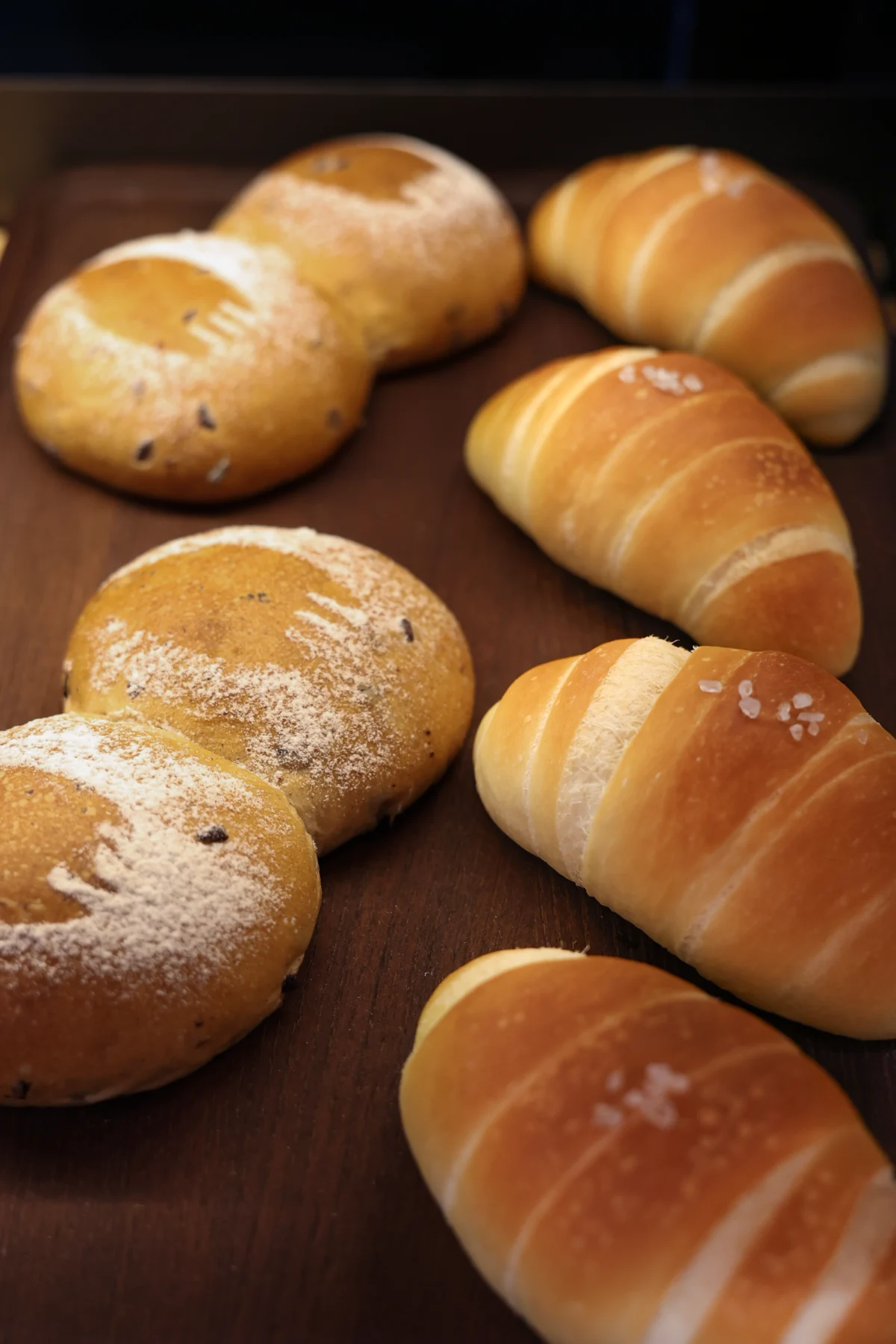 Taiwanese-style horn breads and flour-dusted buns on a tray